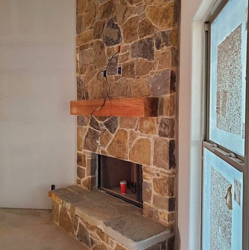 Interior floor-to-ceiling stone fireplace by Mendoza Masonry