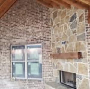Covered patio fireplace in brick and stone